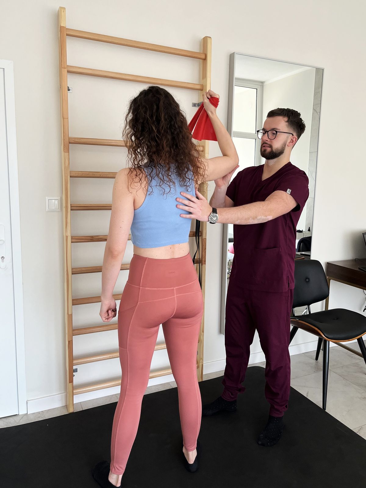 Ćwiczenia korekcyjne z taśmą przy drabince - korekcja wad postawy w gabinecie fizjoterapii w Toruniu